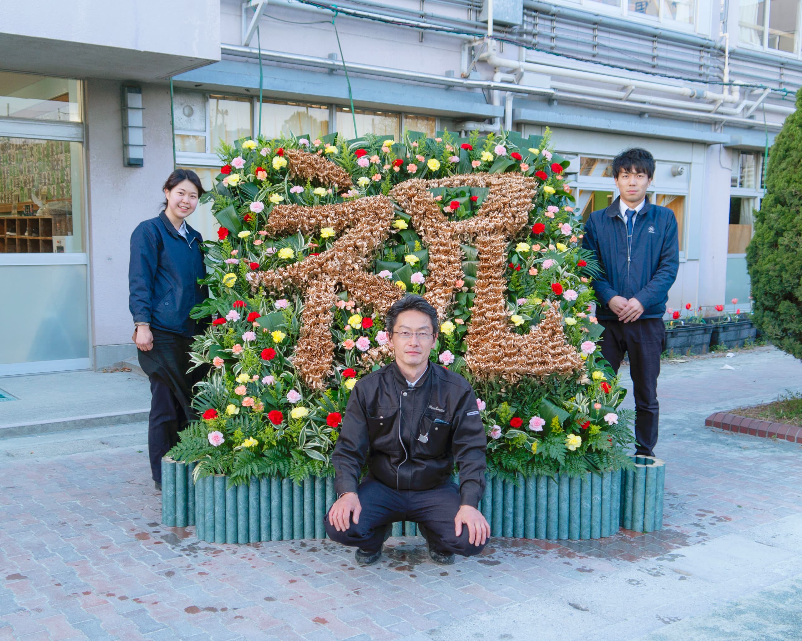 花(菊)約600本を使い、世田谷区の小学校卒業式へ花を添えたサプライズ演出。花で描く “祝” 華魅(ハナミ)