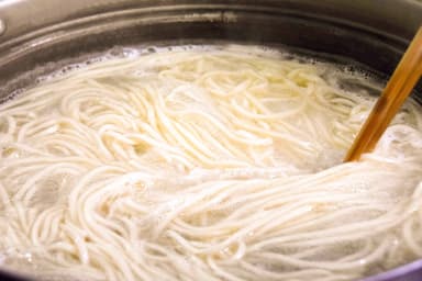 大きな釜で茹で上げる麺