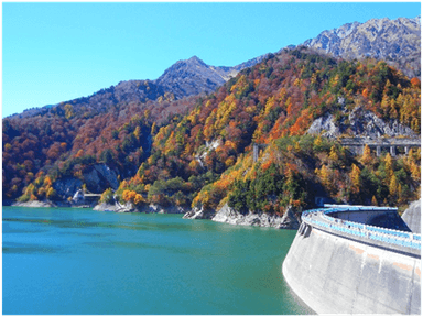 彩り鮮やかな紅葉の山肌に囲まれた黒部ダム湖畔