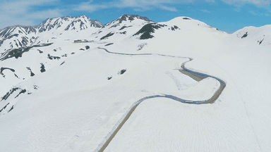 青空に映える圧巻の雪壁、世界一と称される白い回廊