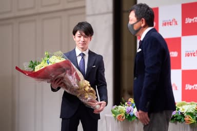 当社取締役会長の中村から花束を受け取る内村航平選手