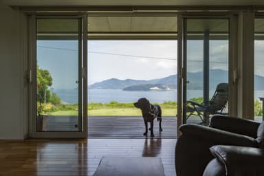 リビングから見るウッドデッキでくつろぐ愛犬と瀬戸内海の島々