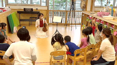 学生講師によるアクティビティ、はじめて耳にするバイオリンの音に興味津々の子どもたち