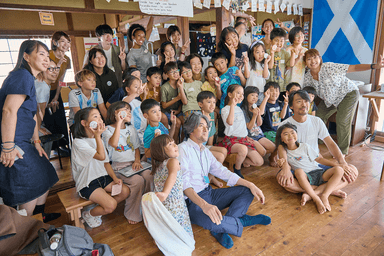 完成した缶バッジを持って笑顔の子どもたち