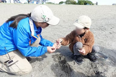 クラフトイベントで参加者とパークコーディネーターが漂着物(貝やマイクロプラスチック)を拾っている様子