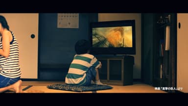 ひとりでTVの「進撃の巨人」映画予告に見入る少年。