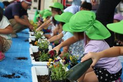 笑顔で花植えをする子供たち