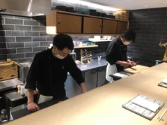 「紡 Dining」の厨房に立つシェフ(奥)と元大黒屋の職人(手前)