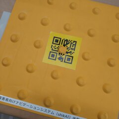 点字ブロックの真ん中に、ナビゲーションシステムの二次元コードが貼られています